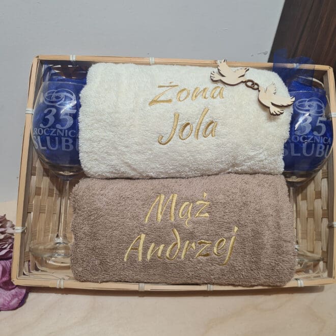 Zestaw z okazji rocznicy ślubu dwa ręczniki kąpielowe i kieliszki do wina zapakowane ozdobnie w koszyk